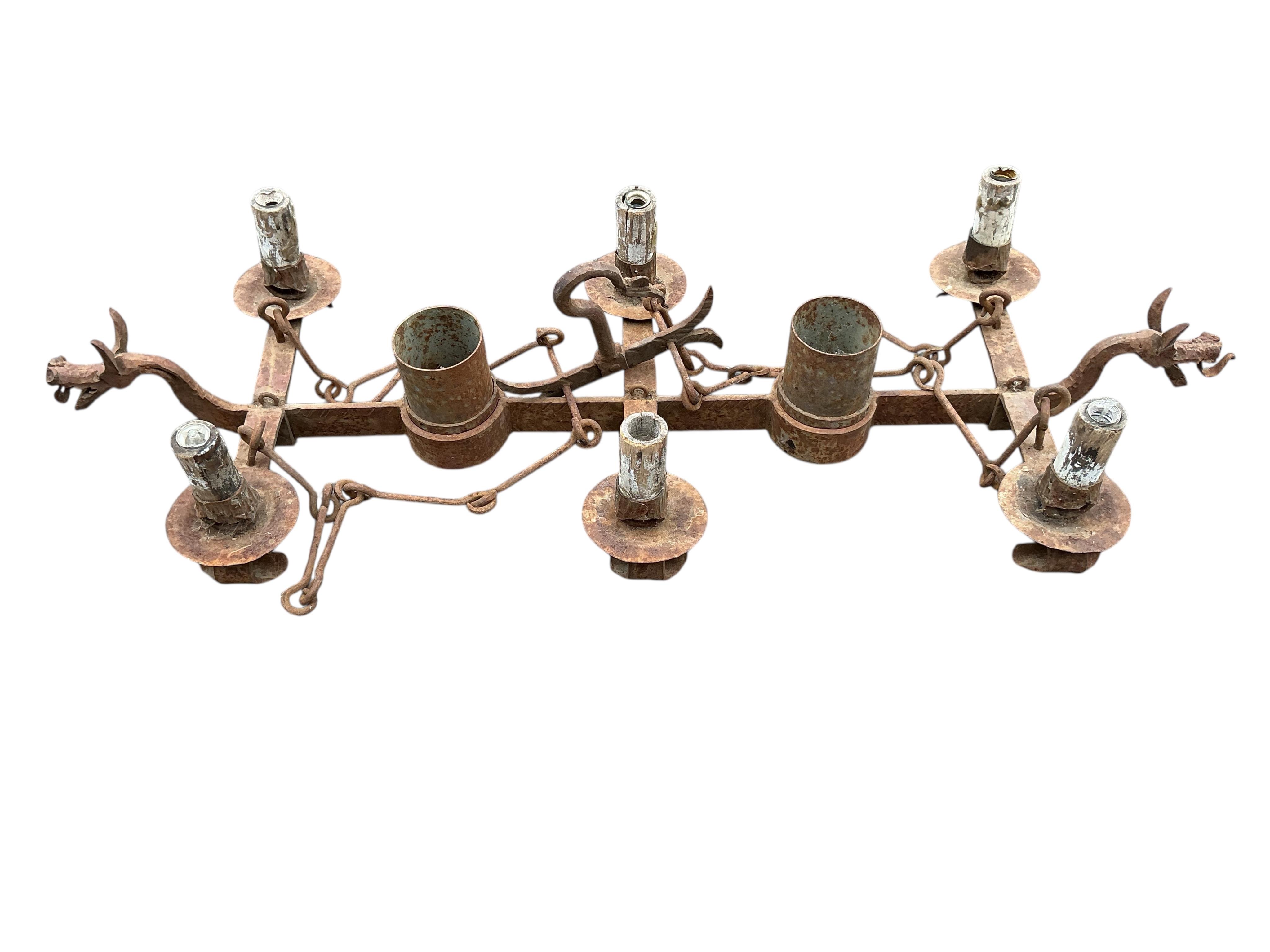 A wrought iron five branch tripod candlestand, height 134cm together with a wrought iron dragon head hanging light fitting